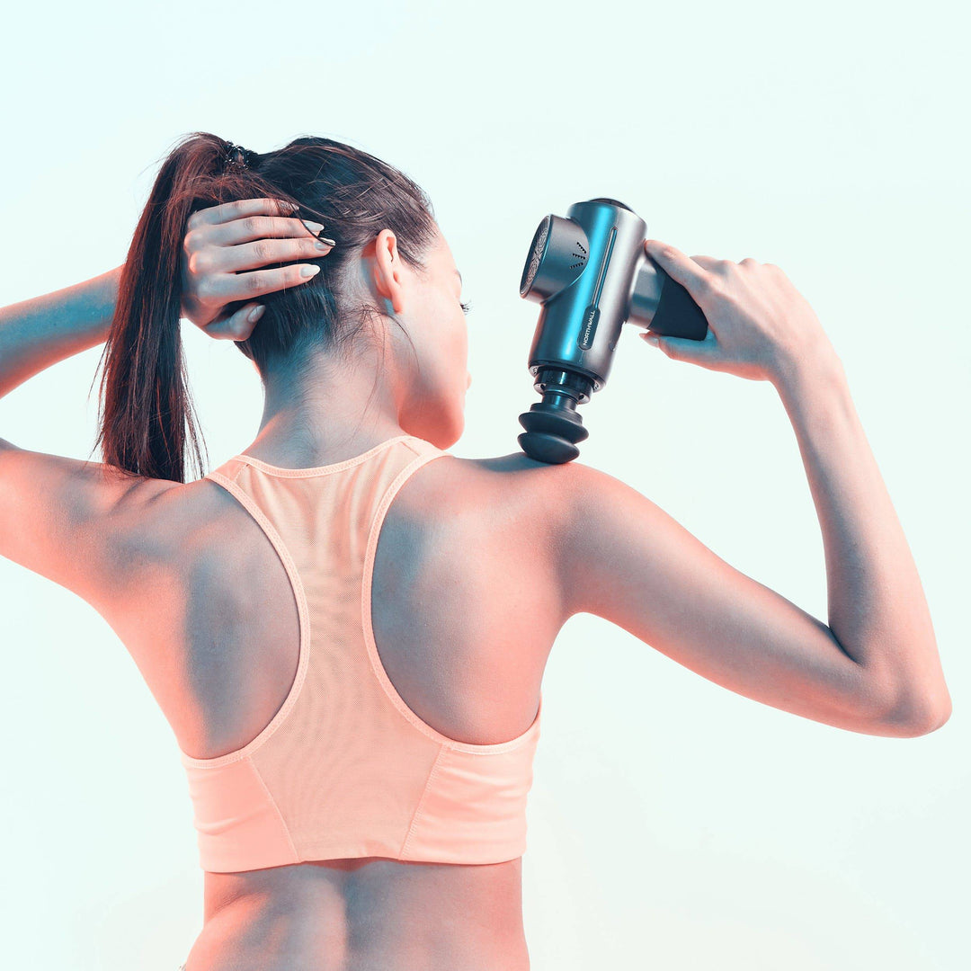 Sportieve vrouw gebruikt massage gun op de schouder