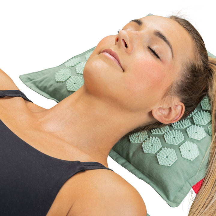 Jonge vrouw ligt met haar hoofd op het Northwall spijkerkussen