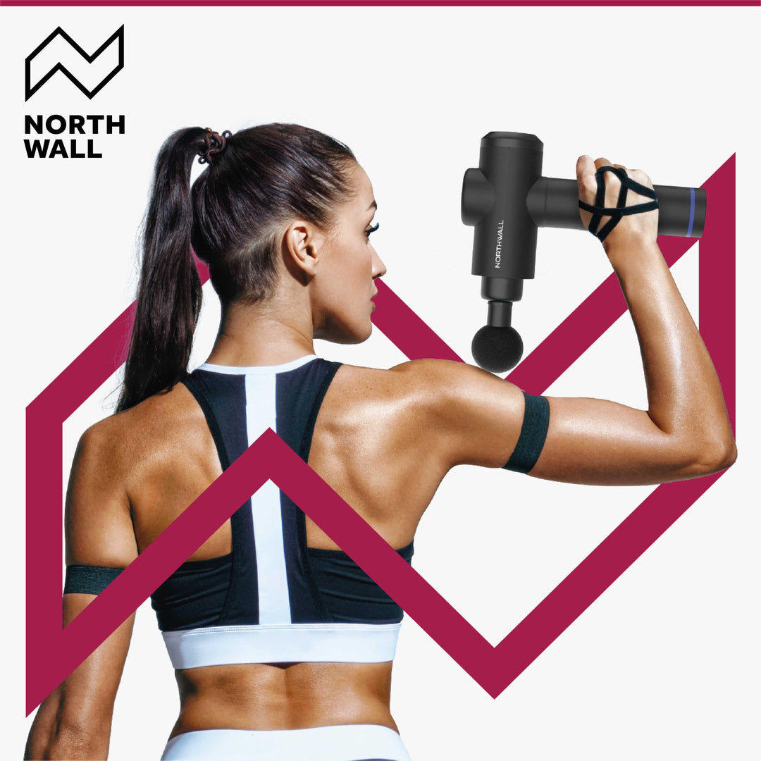 Sportieve vrouw masseert haar schouder met het massage gun